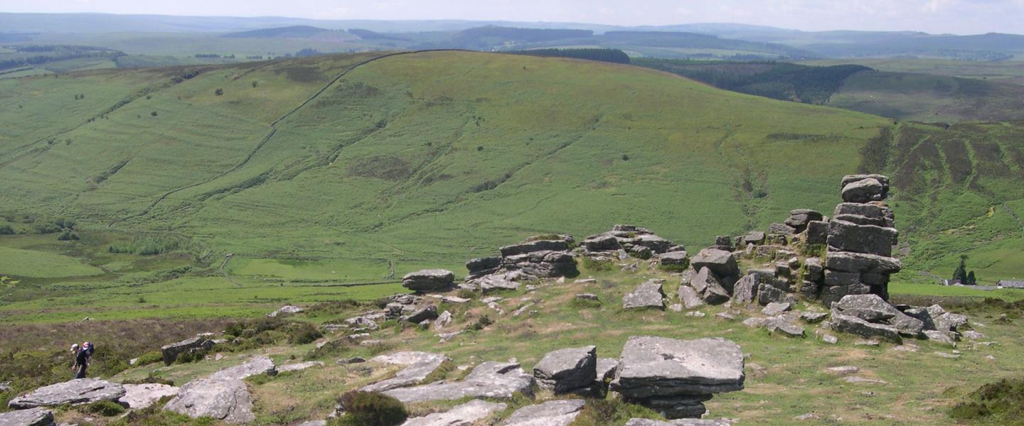 Grimspound, a late Bronze Age settlement, rock circles surrounded by a low stone wall.