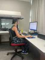 Student working at a desktop computer, next to a large-format flat-bed scanner in SSU Library's Special Collections