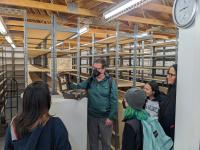 Professor shows an early 20th century fingerprinting kit to four students in the Anthropological Studies Center's Collections Facility