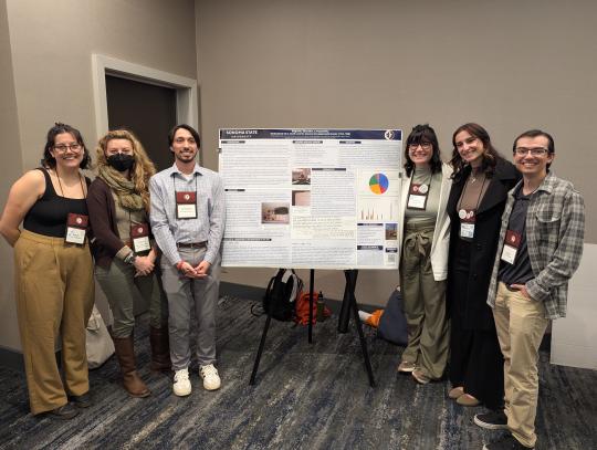Six students standing on either side of a research poster at the Society for California Archaeology annual meeting in 2025.