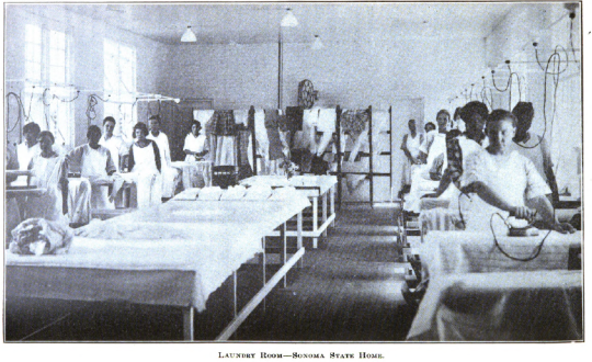 Women in Laundry Room of then-Sonoma State Home ca. 1919. They are standing behind large ironing boards, and some are ironing.